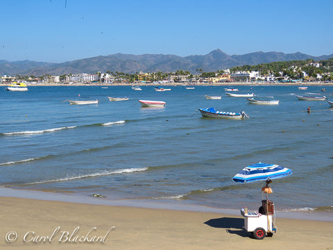 Beautiful blue water beach with mountains behind