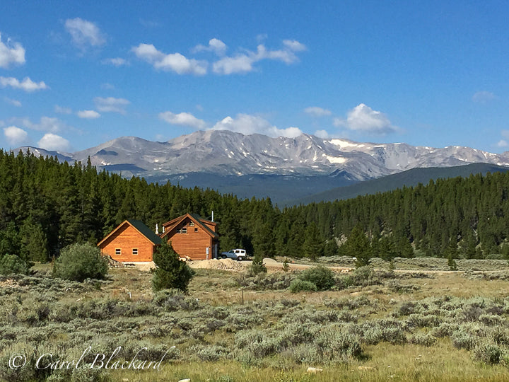 Wood home with mountains and pine trees