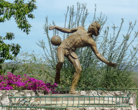 Statue of prehispanic Mexican man playing ball off his hip.